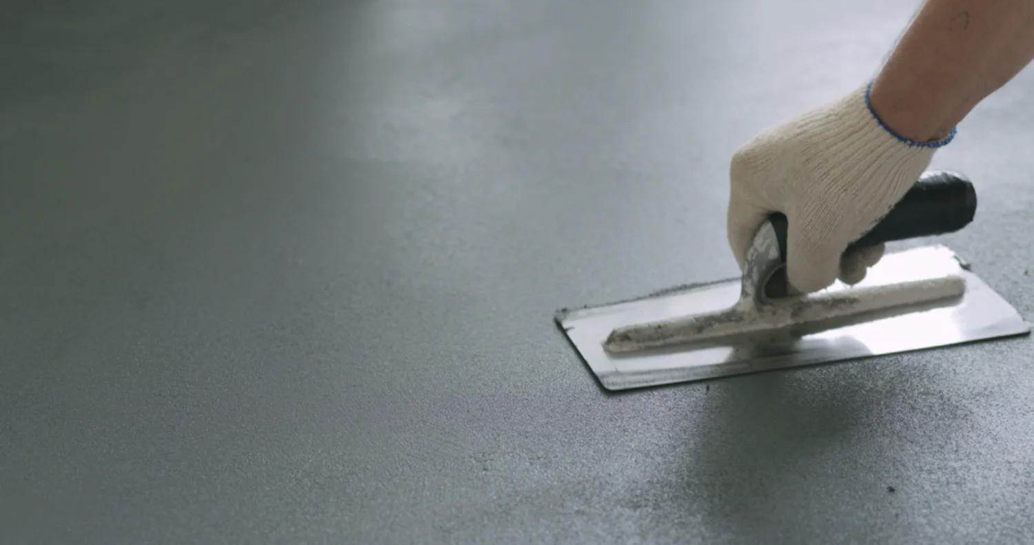 Concreter hand-finishing a smooth concrete surface